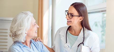 a grandmother and a doctor smiling to each other